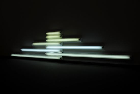 Eight light tubes attached to a black wall