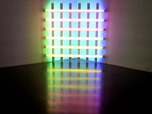 Six florescent lights on a black frame in a dark corner