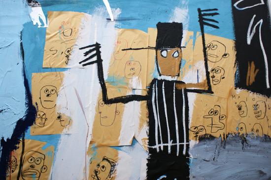 A man in black and white stripes against a background of drawings of people
