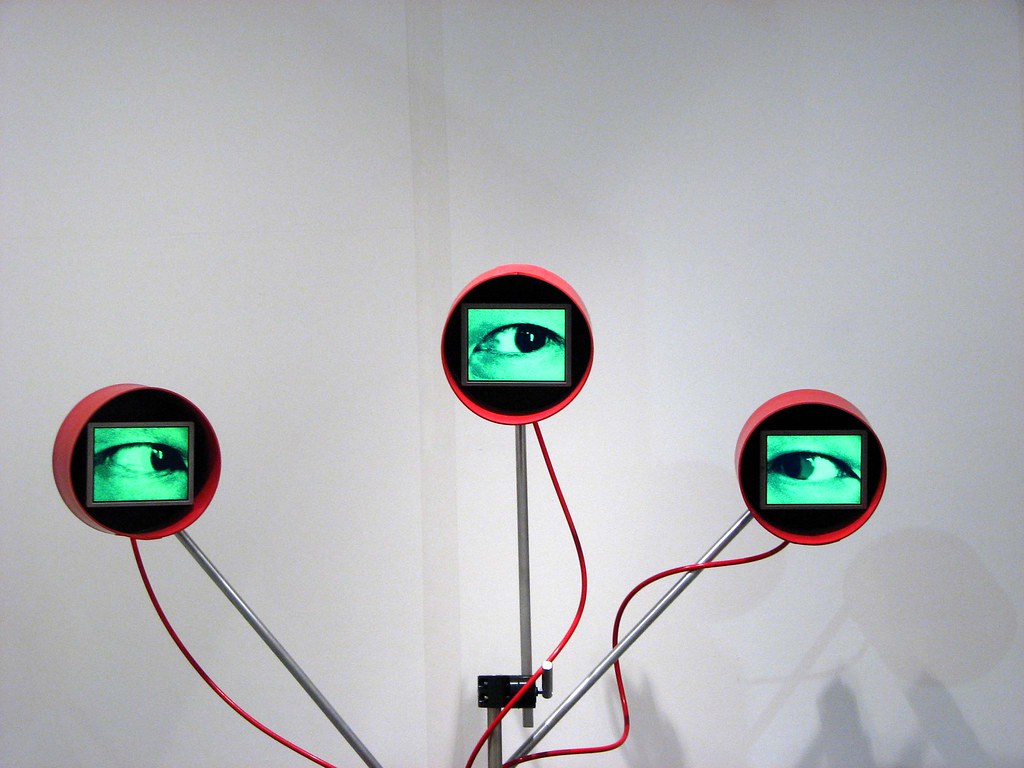 Three red circles with tv monitors with green eyes