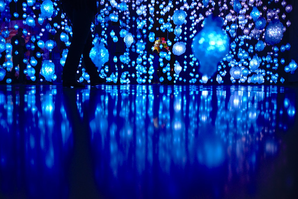 blue lights strung from the ceiling reflect off a black floor