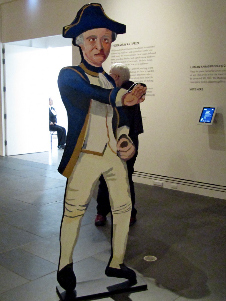 Statue of a man wearing white vest and pants with blue hat and coat