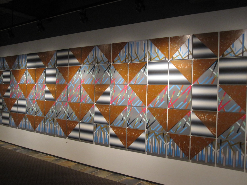 A large installation of colored panels, some white and black, some blue and brown