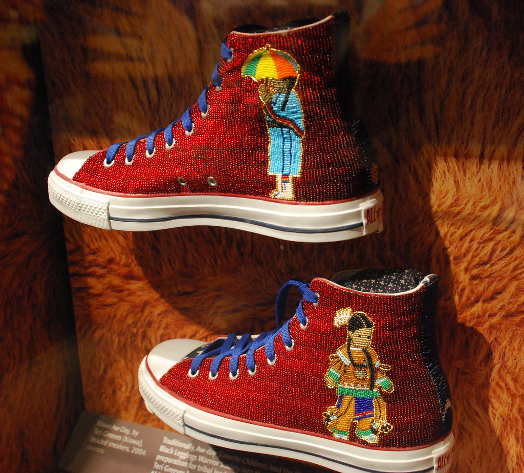 red beaded sneakers with a woman on each side in colorful clothing
