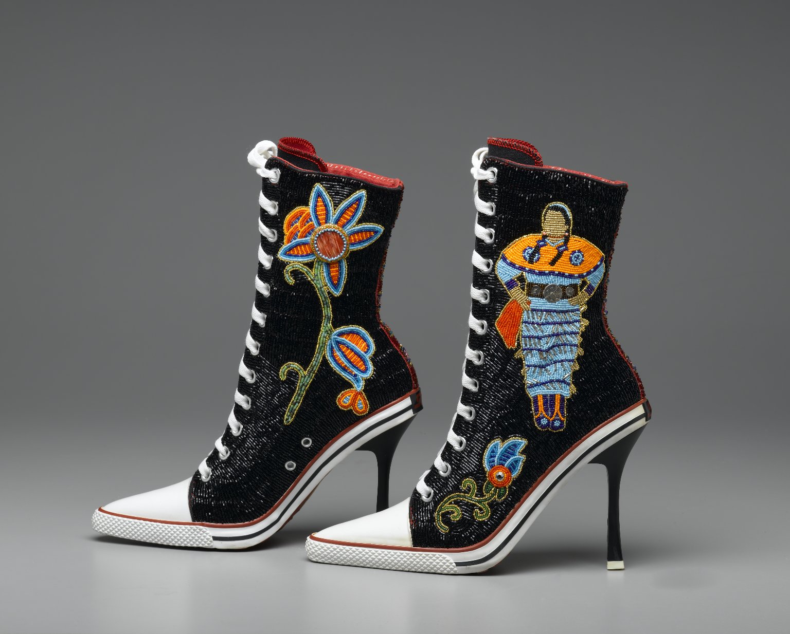 Zapatillas negras con cuentas sobre tacones altos con una colorida flor de pedrería y mujer