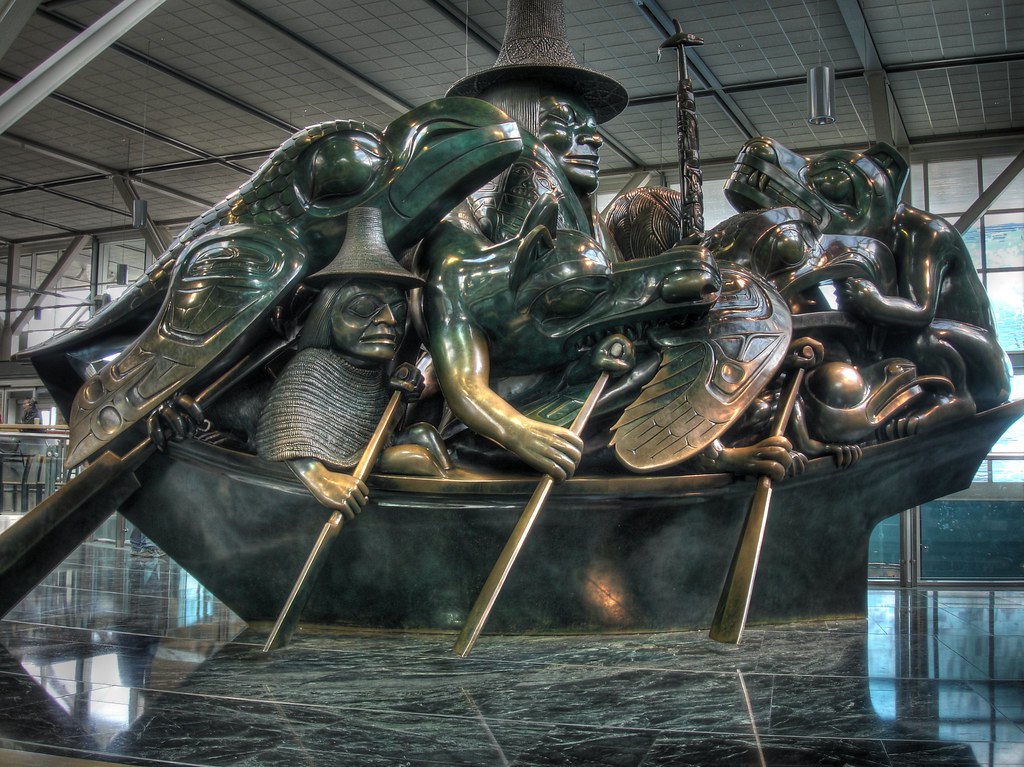 A bronze statue of a boat with a man, several birds and animals rowing