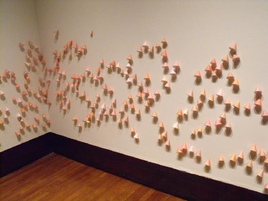small rolled paper comes glued to a wall in multiple colors of tan