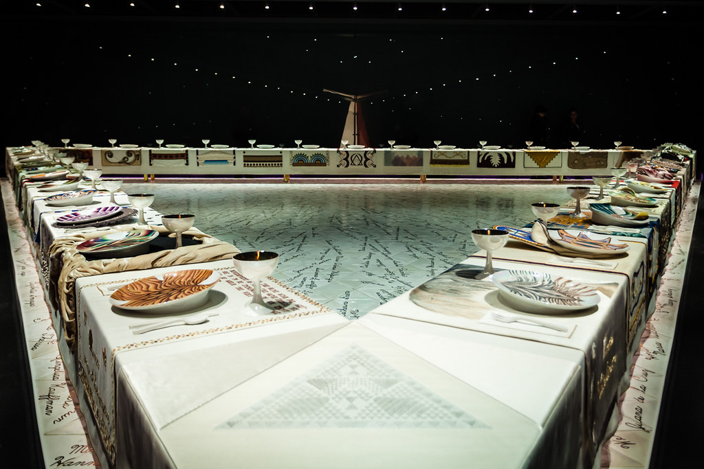 a triangle dinner table on a pedestal with 39 plates made out of ceramic