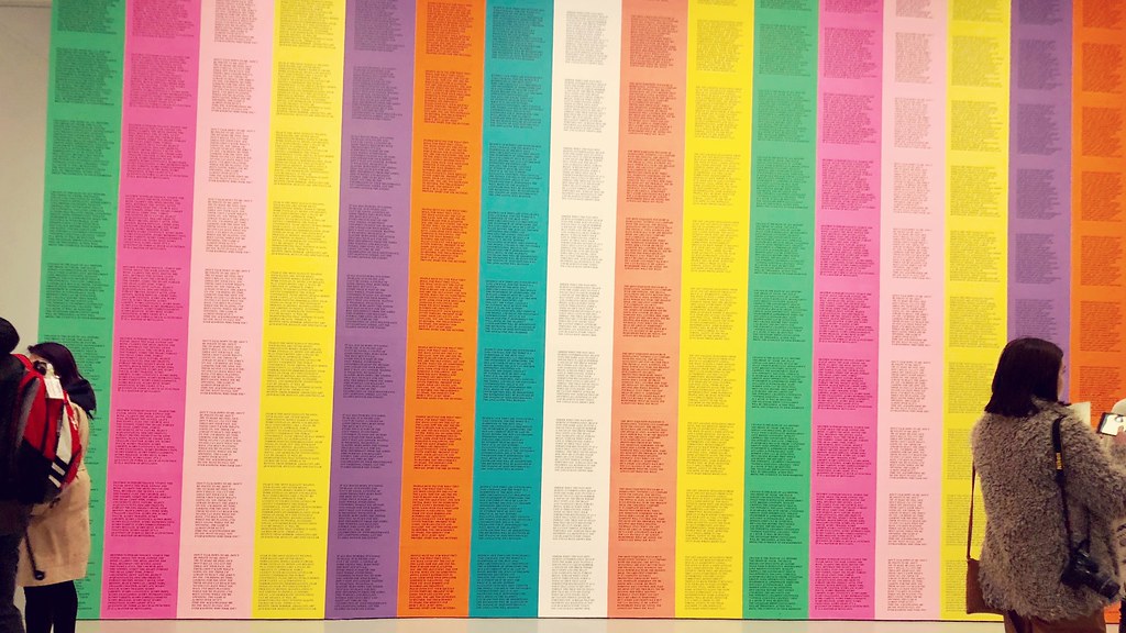 cientos de papel impreso pegado a una pared en un pelado de arcoíris