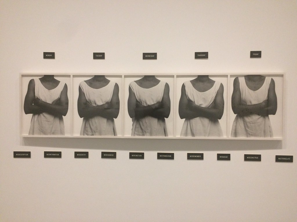 П'ять жінок, одягнених у білі сукні без рукавів з текстом зверху і знизу мистецтва