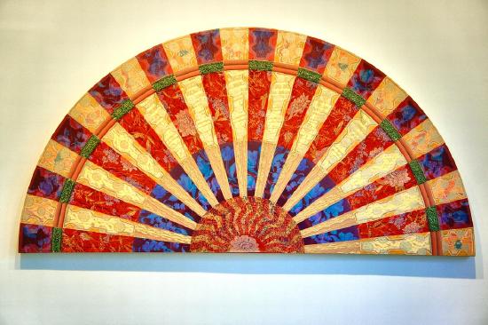 A large fan in yellow red and blue in alternating rows of color