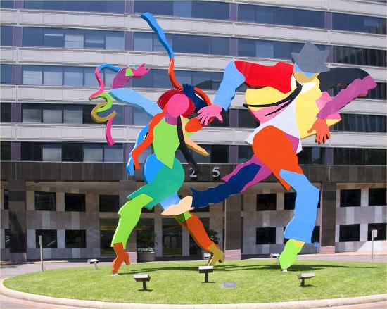 a large metal structure of two people dancing with very bright colors