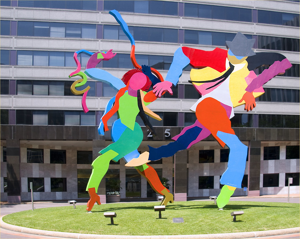 a large metal structure of two people dancing with very bright colors