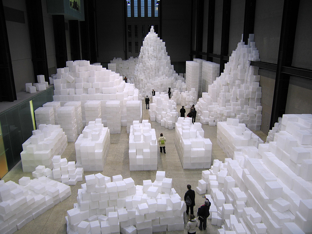 white forms in various sizes stacked on top of each other in a large room