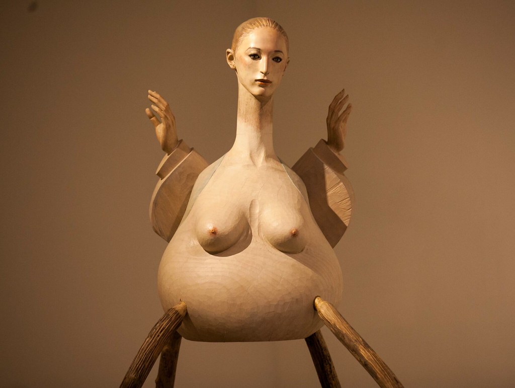 a nude woman with sticks for legs, short arms and a large belly