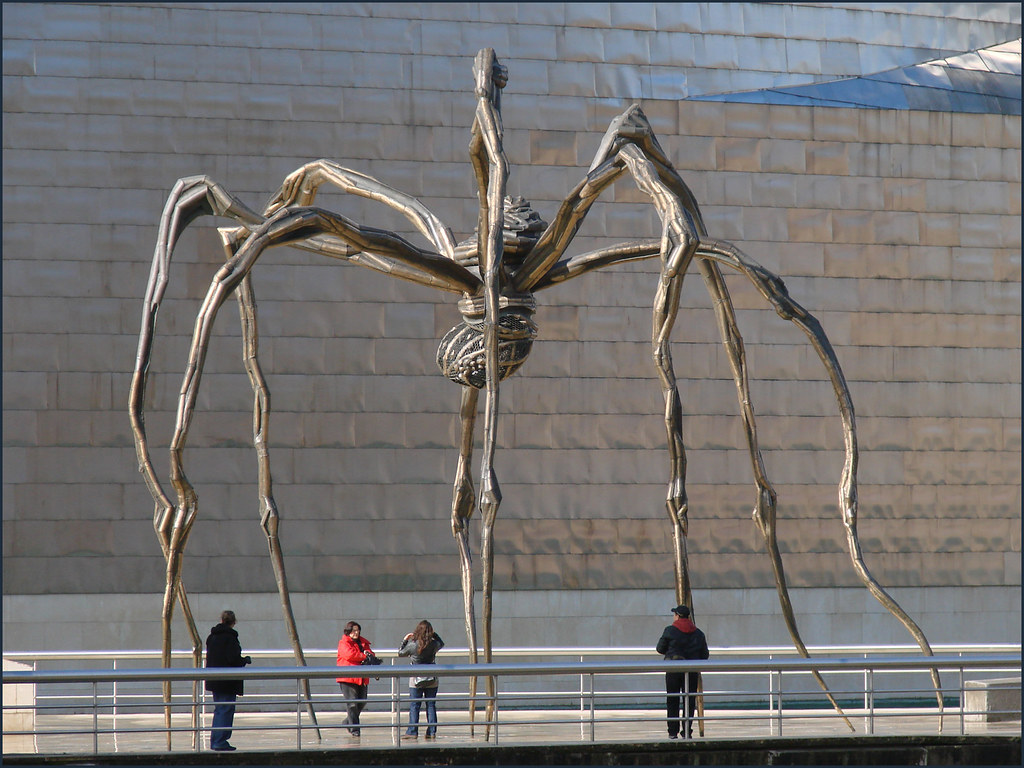 a very large bronze sculpture of a spider in an outdoor setting