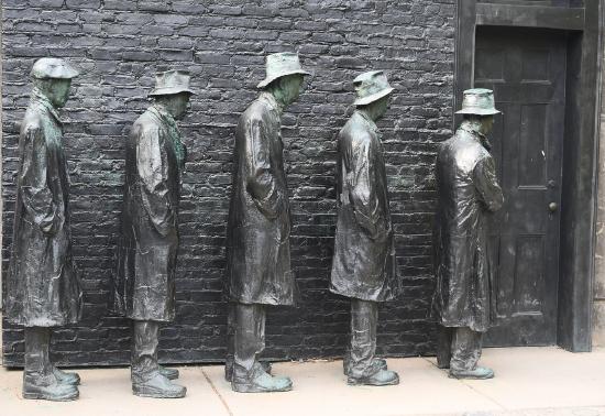 Five men standing in a line made out of bronze