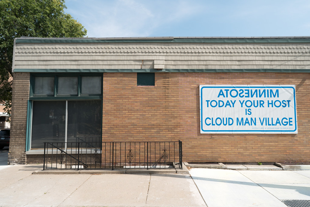 a brick building with a sign on white with blue letters