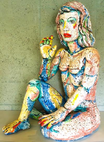 A woman sitting on the floor with bright colors painted on her