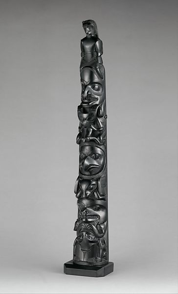 A totem pole carved depicting many animals