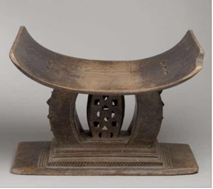 a wooden carved bench for one person in a crescent shape