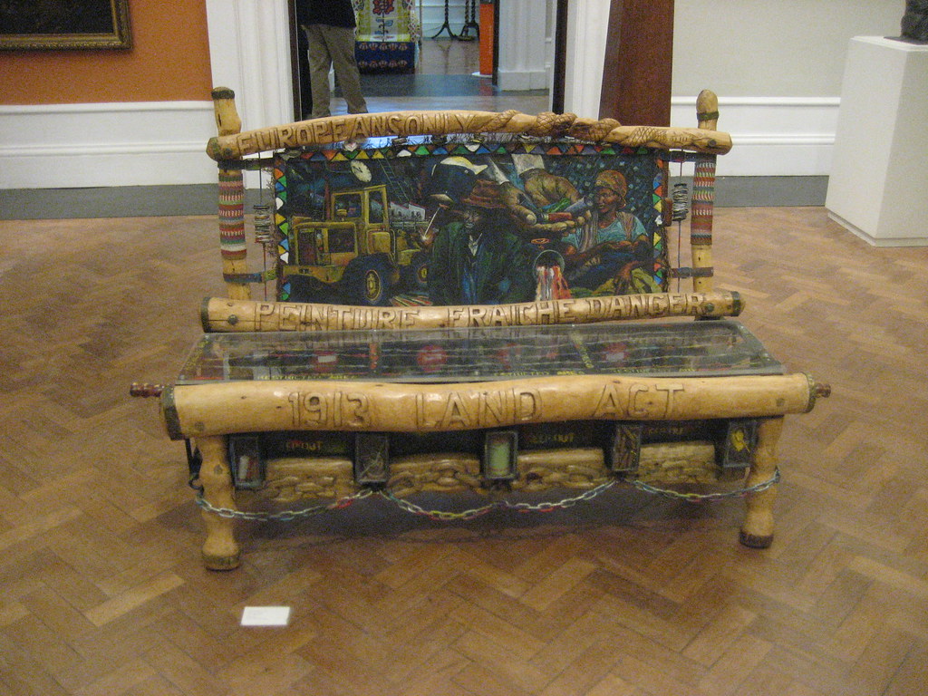 a bench with a mural for the back and large wood beams for the structure
