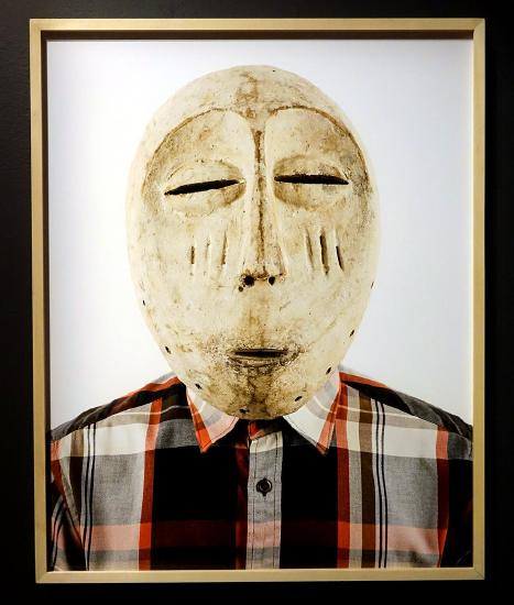 man wearing a mask of white paint with slits for eyes, nose, and mouth