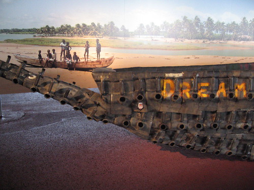 a picture of several people on a boat in the water with a metal boat in the foreground