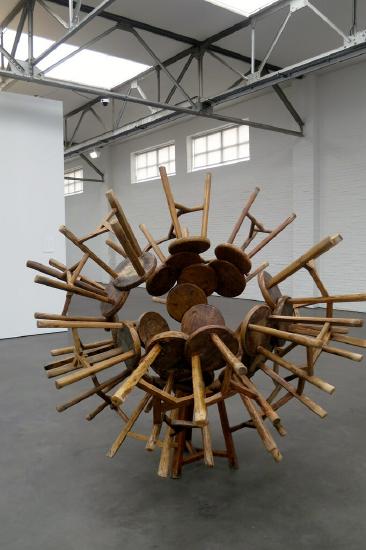 Wooden stools glued together in a large sculpture