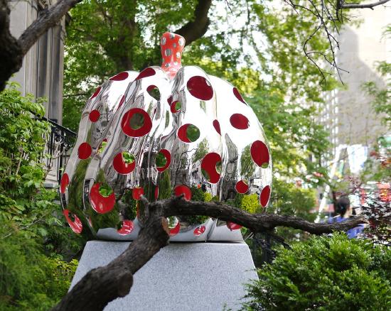 a large metal pumpkin with dots cut out and the inside painted red