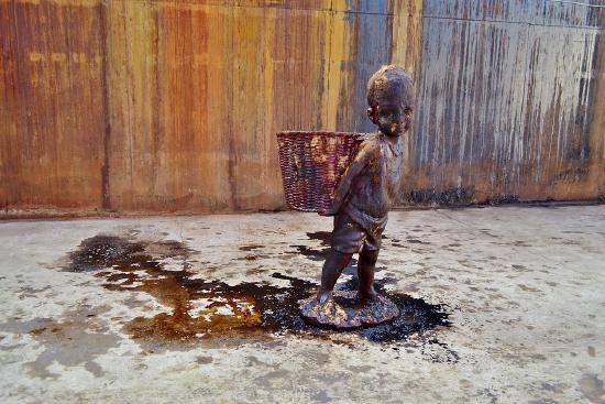 A standing boy holding a woven basket
