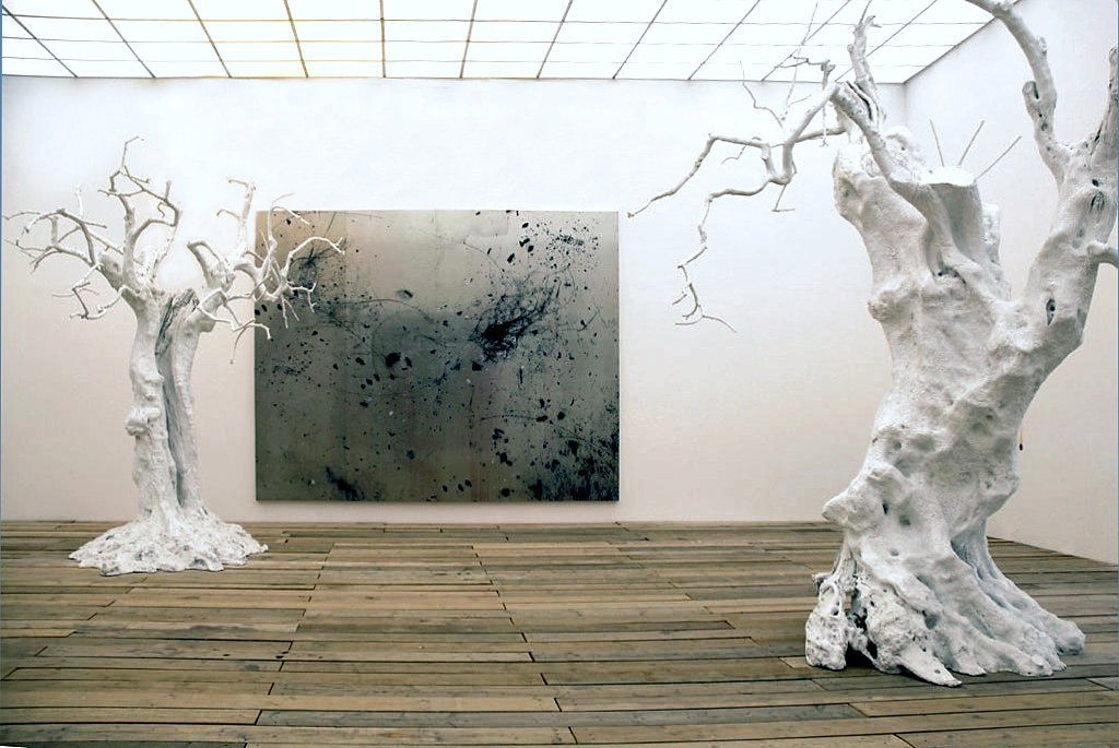2 very old trees painted white inside a museum