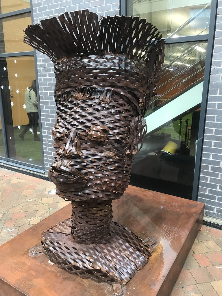 una gran escultura metálica de una persona con tocado
