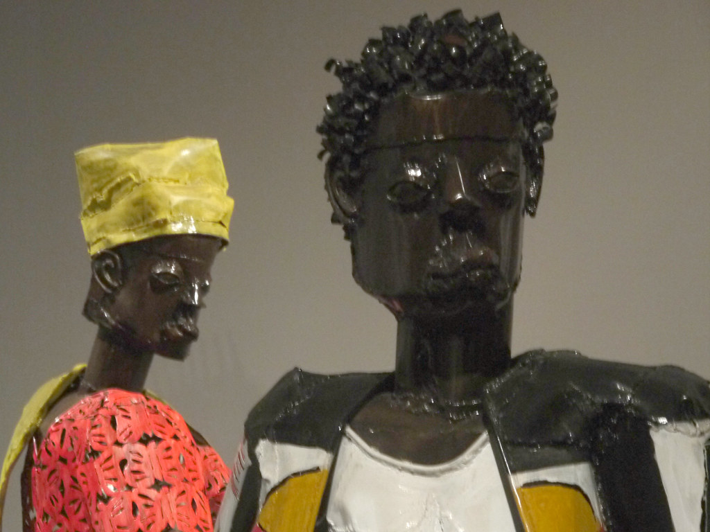 metal sculptures of a man and a woman wearing brightly colored clothes