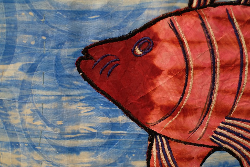 a red fish on a blue background sewn like a quilt