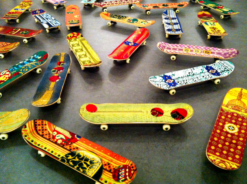 several skateboards painted in bright colors on a cement floor