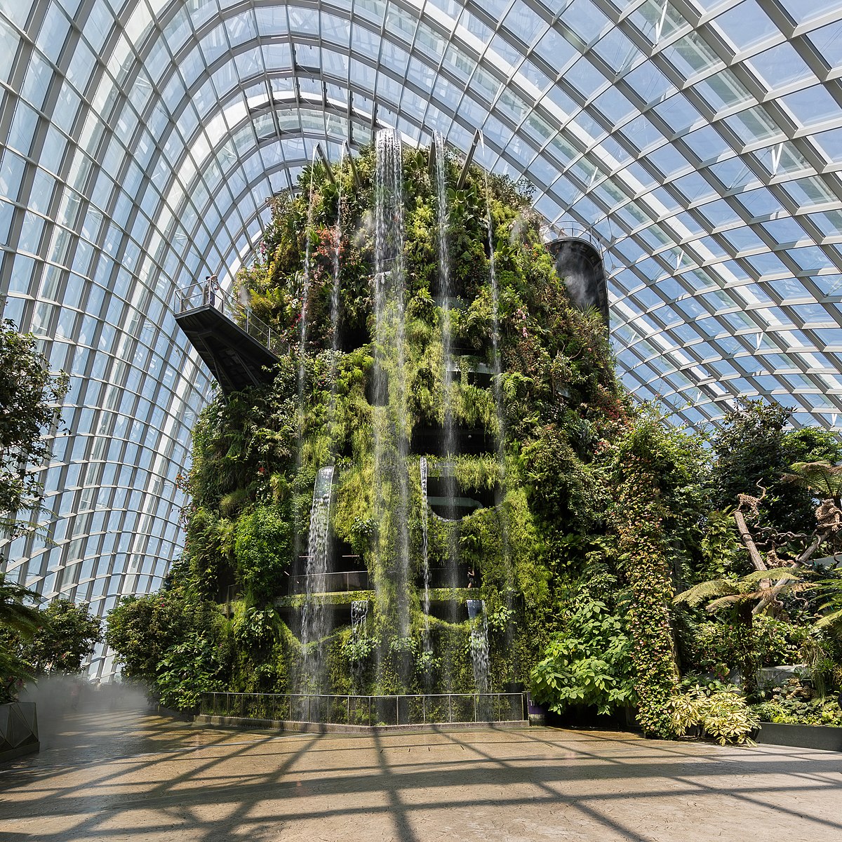 inside a window building with a water fall and greenery