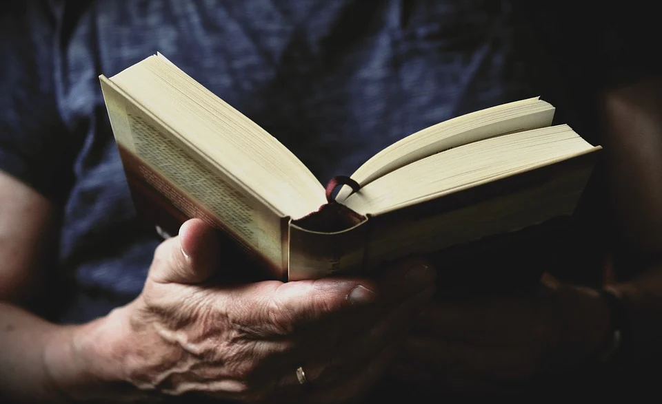 Close-up picture of an open book in a man's hands