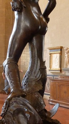 A naked bottom and boots of David standing on a helmet