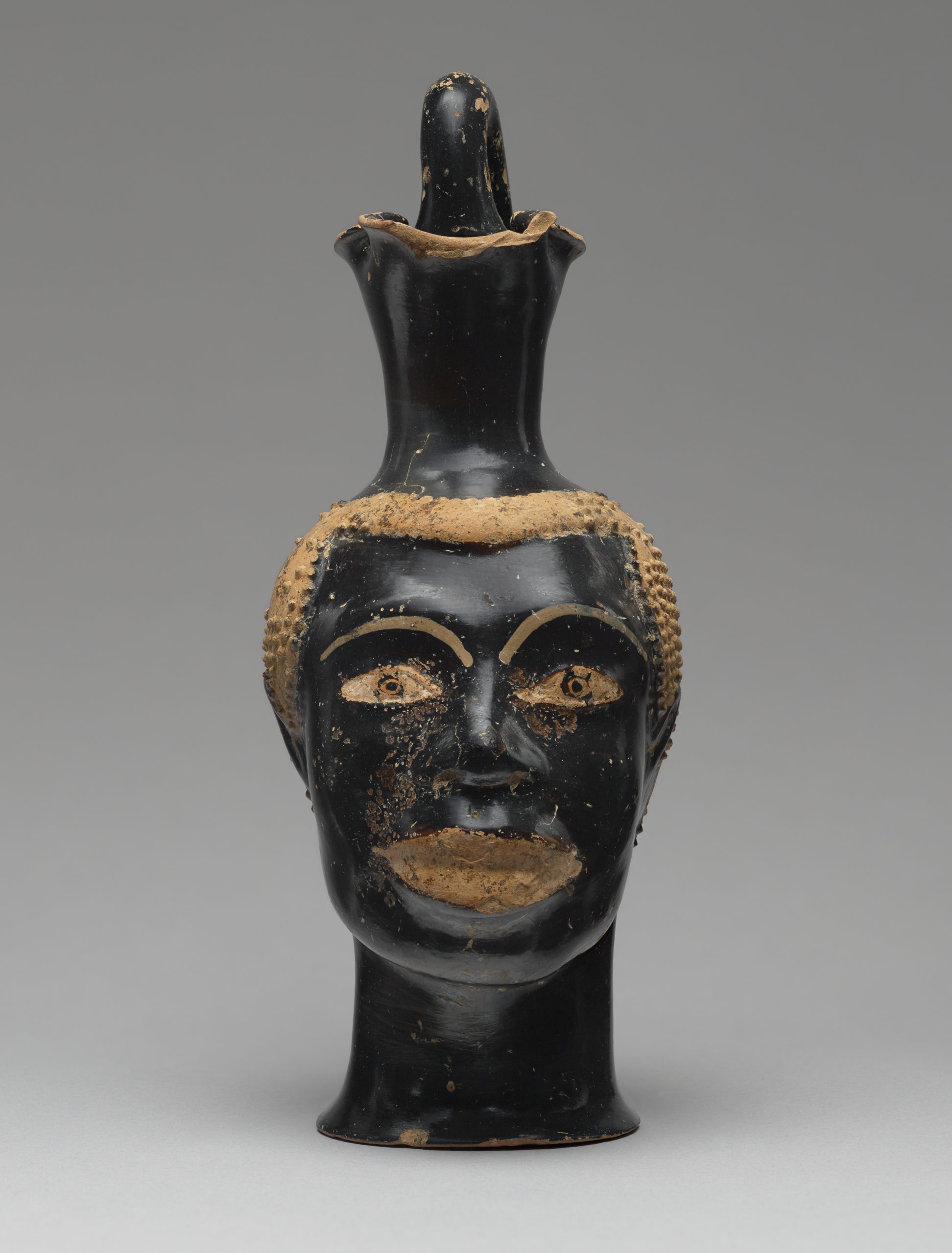 Pitcher (Oinochoe) in the Form of the Head of an African, about 510 B.C.E., attributed to Class B bis: Class of Louvre H 62. Terracotta, 8 7/16 inches high (The J. Paul Getty Museum, 83.AE.229. Digital image courtesy of the Getty’s Open Content Program)