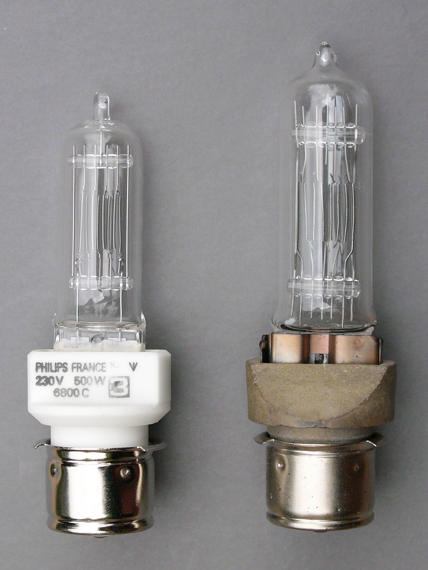 Two squat, tubular light bulbs with silver metal circular connectors at the bottom. 