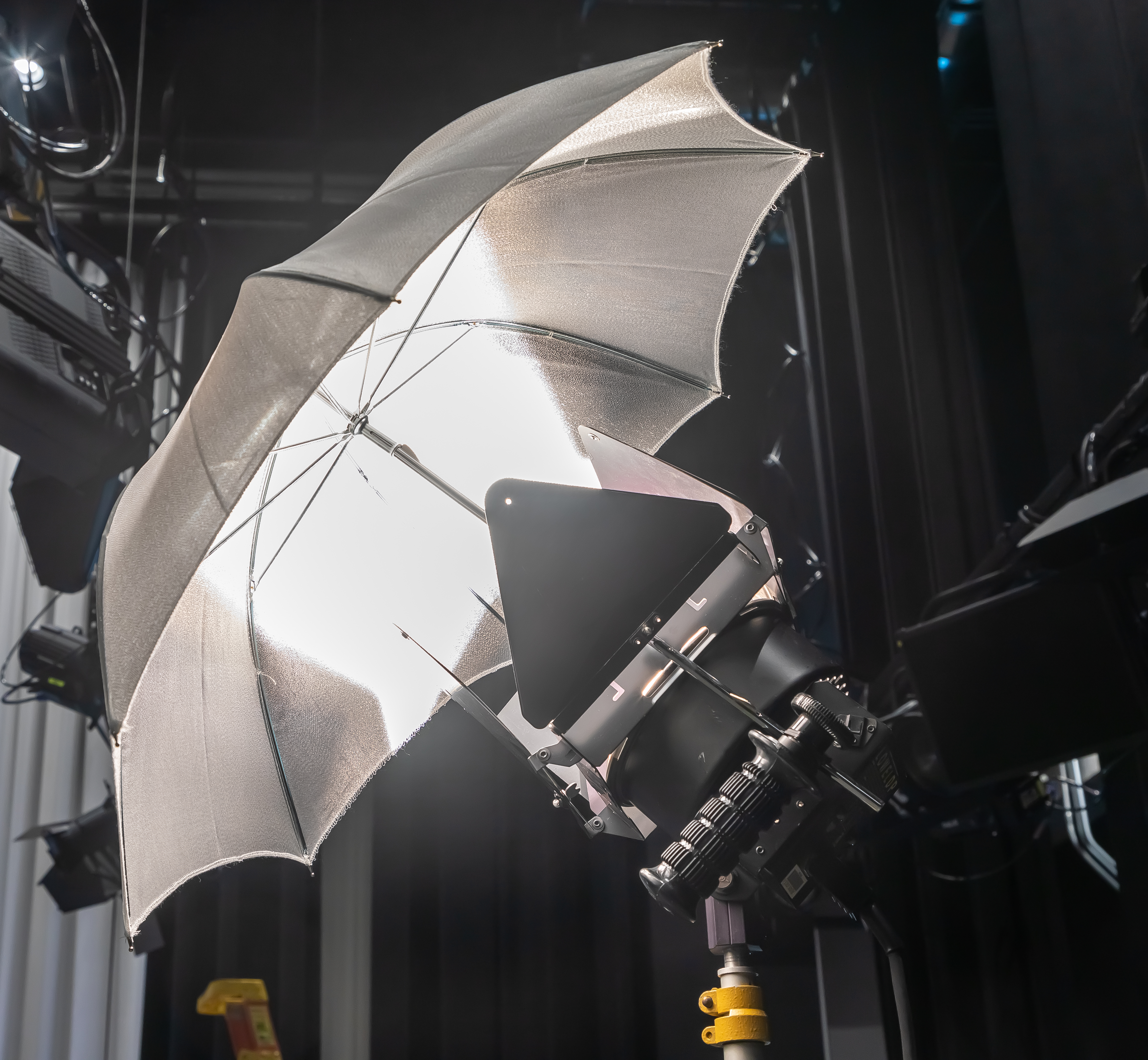 A fresnel light shining light into an attached umbrella that has reflective material inside. 
