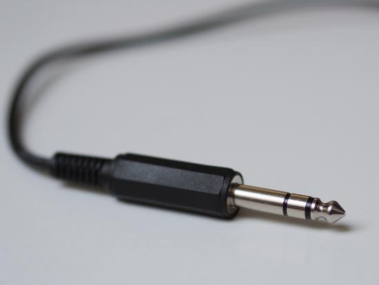 A wire with cylindrical black end with a metal cylinder coming out of it that has a bulb head. 