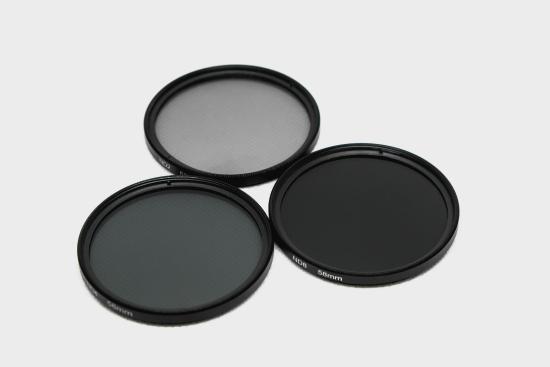 Top of ND2, ND4, and ND8 filters laid next to each other. We see the lenses getting darker as the ND number increases. 