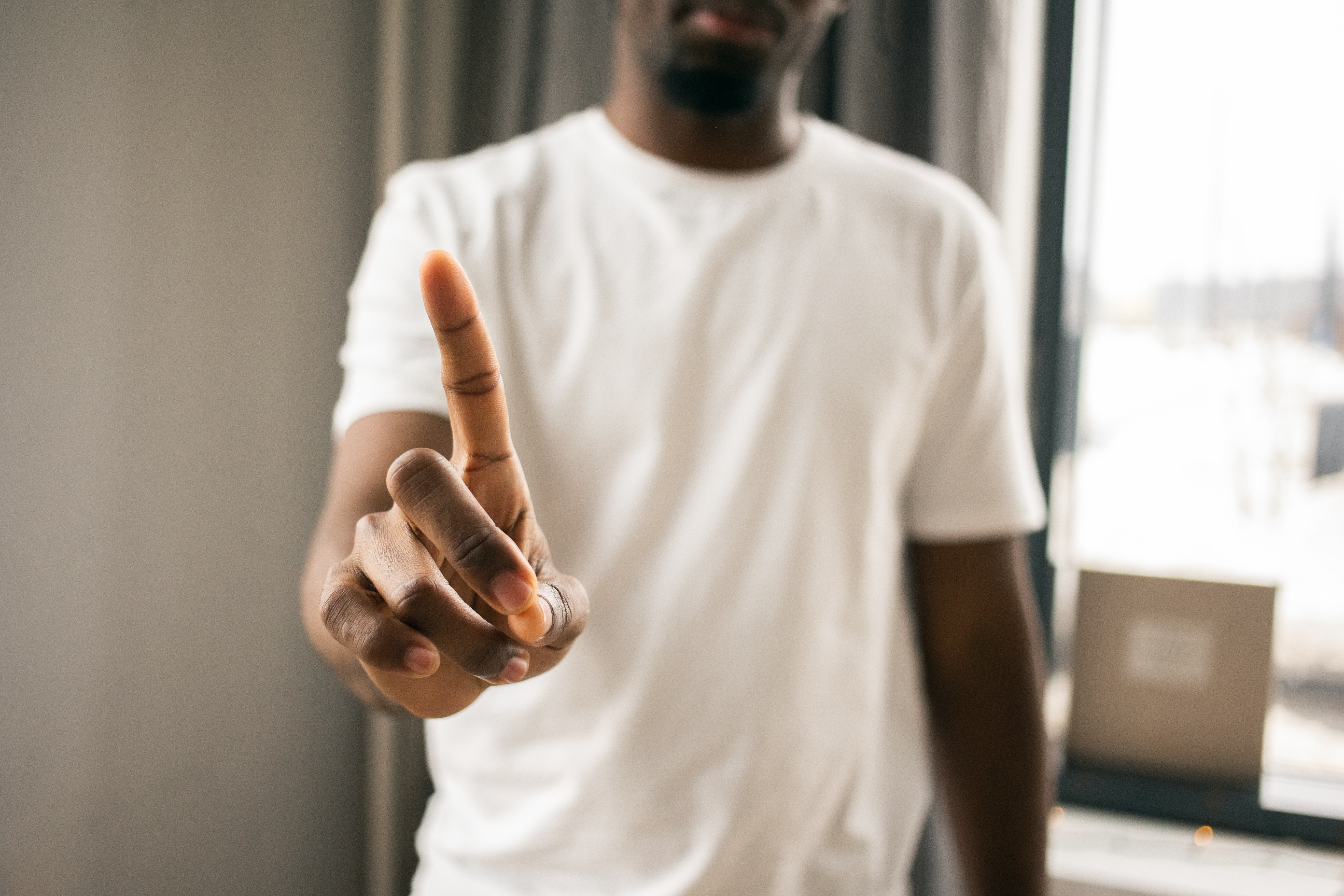 A black man shows the no sign with his index finger.