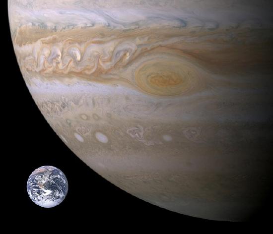 Part of Jupiter next to a much smaller Earth.
