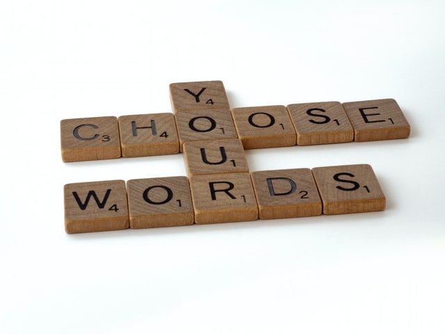 Les mots « choisissez » et « mots » horizontalement, liés par le mot « votre » verticalement, le tout en lettres Scrabble.