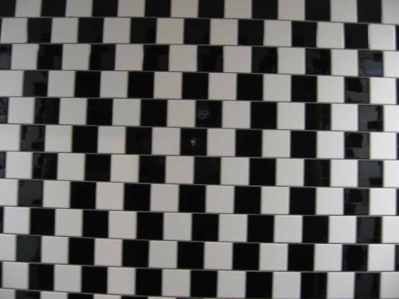 Um tabuleiro quadriculado preto e branco com quadrados que não se alinham diretamente um sob o outro cria a ilusão de que os quadrados não são do mesmo tamanho.