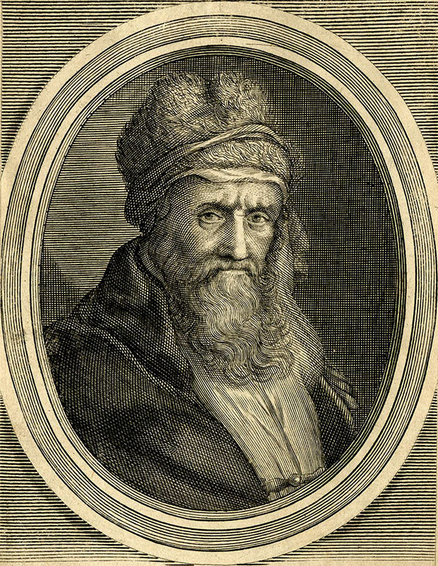 An older Laërtius with a long beard, heavy eyebrows, and a wool hat looks outward with a serious expression.