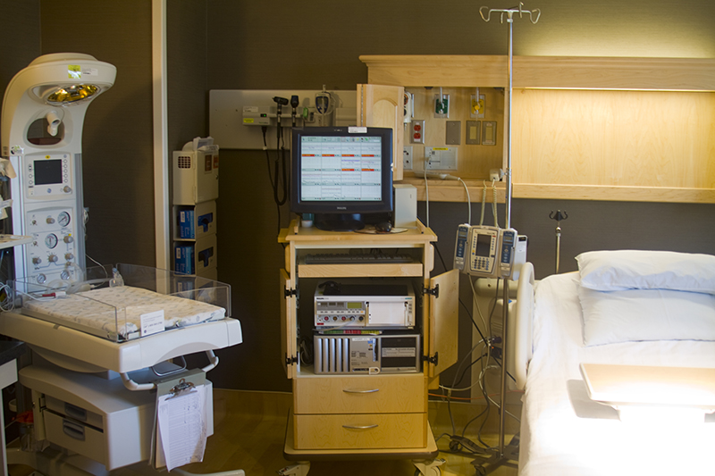 Лікарняна кімната з багатьма одиницями медичного обладнання.
